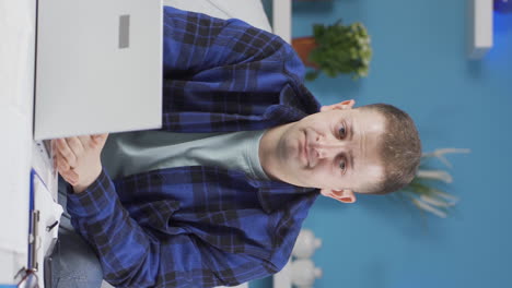 Vertical-video-of-Home-office-worker-man-looking-annoyed-at-camera.